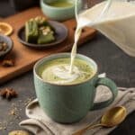 Pouring steamed milk into matcha and chai mix for latte